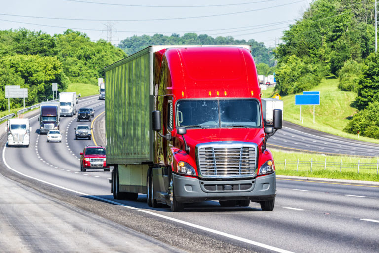 An image of a semi truck on a busy highway.