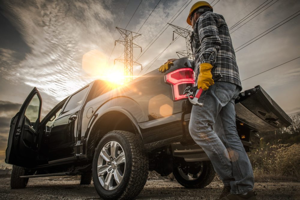 An image of a skilled trades worker getting ready to get into a pickup truck.