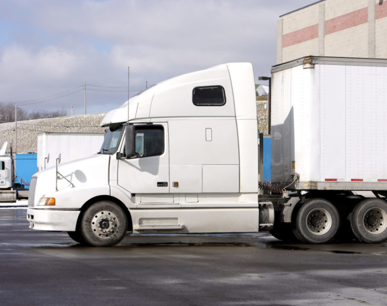 An image of a white semi truck in a loading bay.